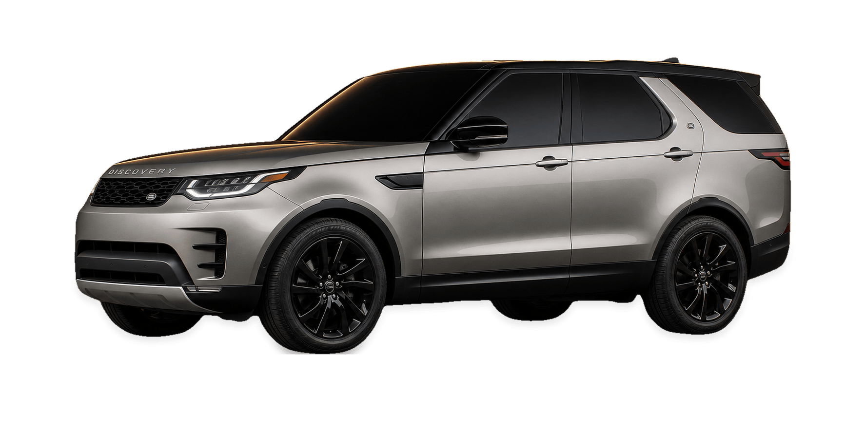 Silver 2019 Land Rover Discovery HSE SUV with a black roof under warm gold rim lighting in a dark studio.