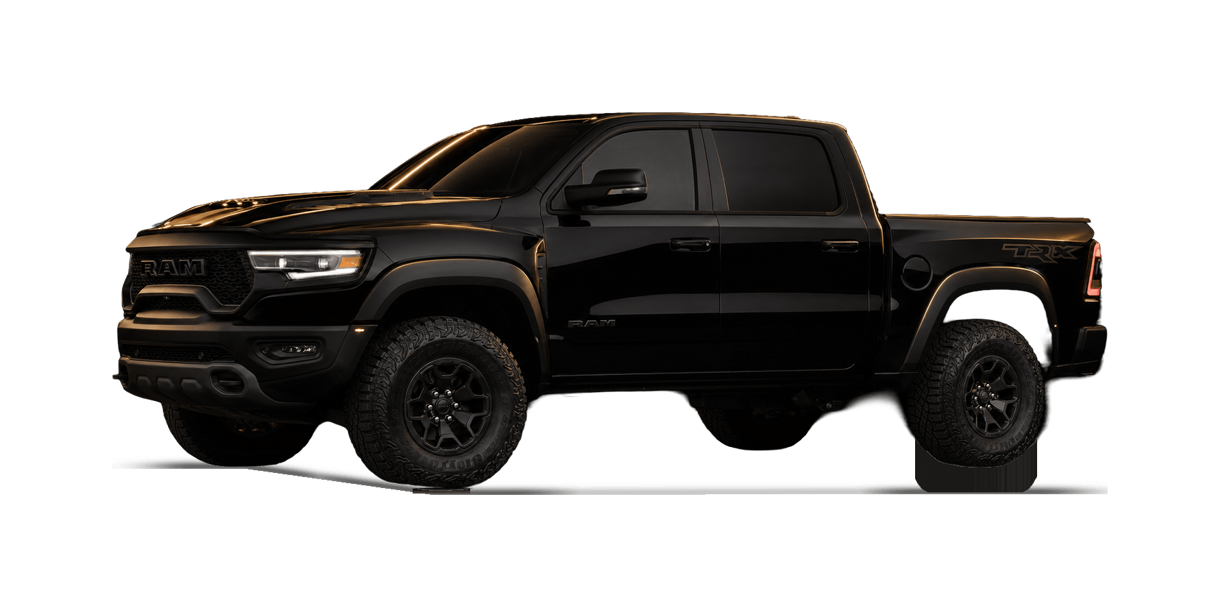 Black 2021 Ram 1500 TRX pickup truck under warm gold rim lighting in a dark studio.