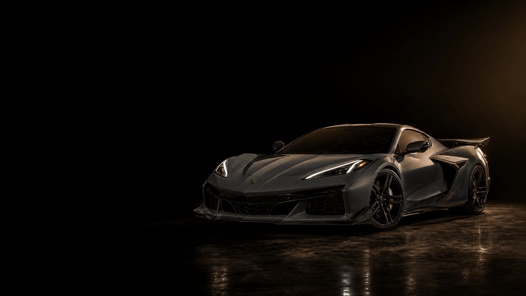 An exotic coupe in three-quarter front view under a low gold rim light on a dark studio ground, with open negative space to the left.